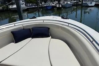 Slide: The Image of 2014 Pursuit S 280 Sport boat with cushioned seating and pillows, docked at marina. - 12