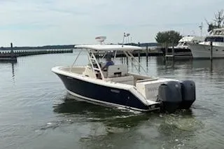 Slide: The Image of 2014 Pursuit S 280 Sport boat navigating calm waters near a marina. - 2