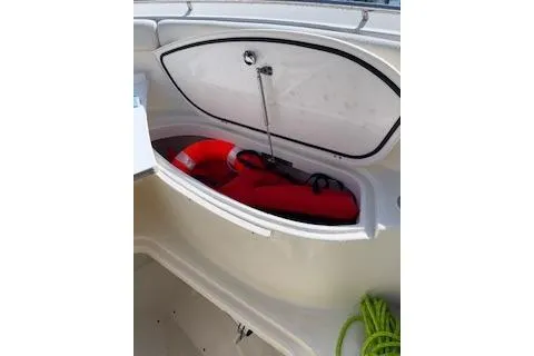 Slide: The Image of Open storage compartment on 2014 Pursuit S 280 Sport boat with life jackets and rope. - 24