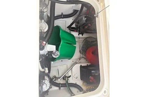 Slide: The Image of Engine compartment of a 2014 Pursuit S 280 Sport boat with visible components and tools. - 25