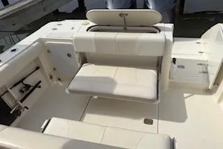 Slide: The Image of 2014 Pursuit S 280 Sport boat interior with white seating and storage compartments. - 27