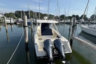 Slide: The Image of 2014 Pursuit S 280 Sport boat docked in a marina with twin outboard engines. - 3