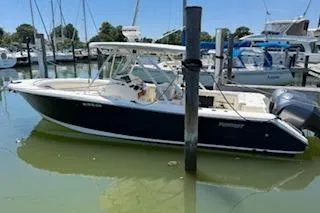 Slide: The Image of 2014 Pursuit S 280 Sport boat docked in a marina, surrounded by other vessels. - 4