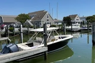 Slide: The Image of 2014 Pursuit S 280 Sport boat docked in a marina with houses in the background. - 5
