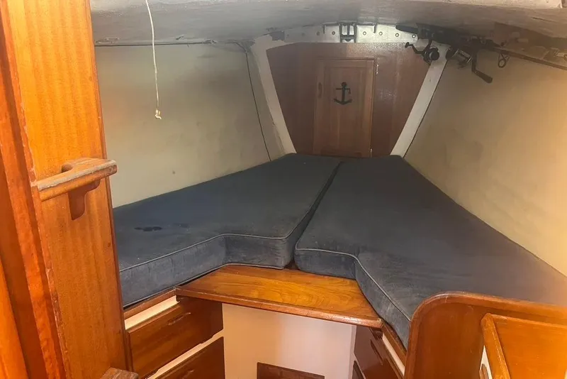 Slide: The Image of Interior cabin of a 1971 Santana 37 sailboat with wooden furnishings and blue cushions. - 12
