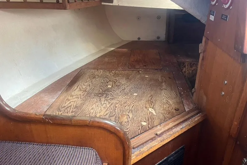 Slide: The Image of Interior of a 1971 Santana 37 sailboat featuring wooden flooring and storage compartments. - 27