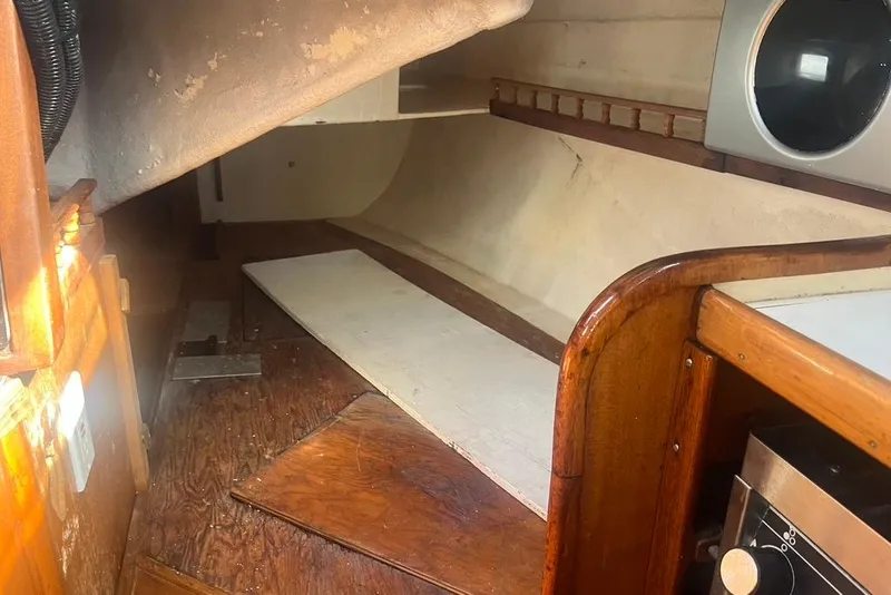 Slide: The Image of Interior of a 1971 Santana 37 sailboat, featuring wooden cabinetry and a compact layout. - 28