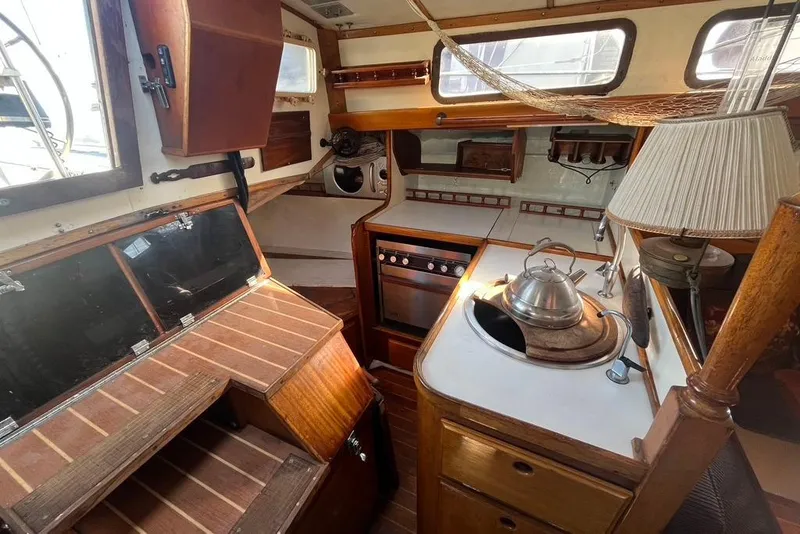 Slide: The Image of Interior of a 1971 Santana 37 sailboat featuring a compact kitchen with wooden cabinetry. - 30