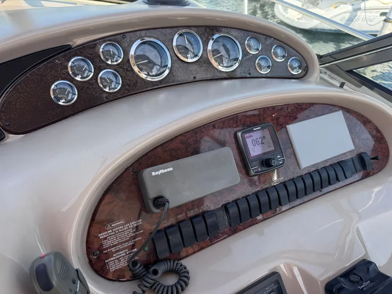 Slide: The Image of 1999 Sea Ray 38 Sundancer dashboard with instruments and Raytheon device. - 16