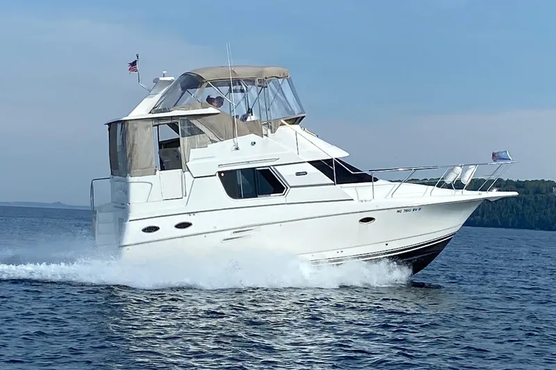 The Image of 1999 Silverton 322 Motor Yacht cruising on open water under clear skies. - 0