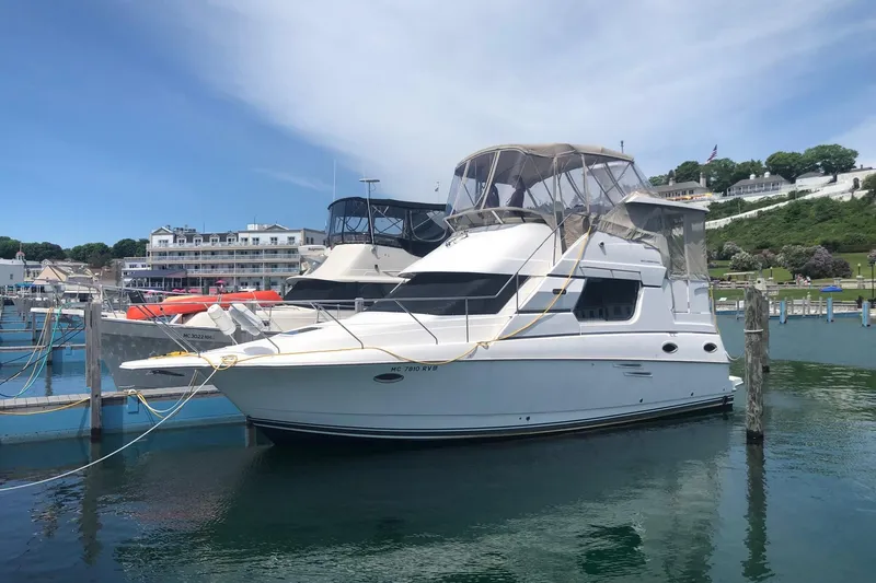 The Image of 1999 Silverton 322 Motor Yacht docked at a marina under a clear blue sky. - 1