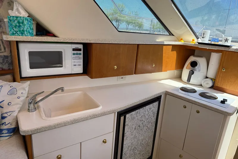 Slide: The Image of 1999 Silverton 322 Motor Yacht kitchen with microwave, sink, and stove. - 10