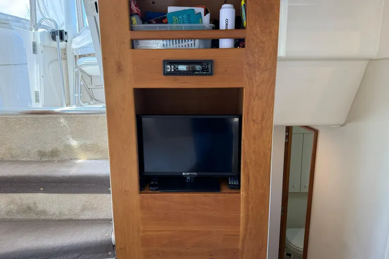 Slide: The Image of Interior of 1999 Silverton 322 Motor Yacht with TV and wooden cabinetry. - 11