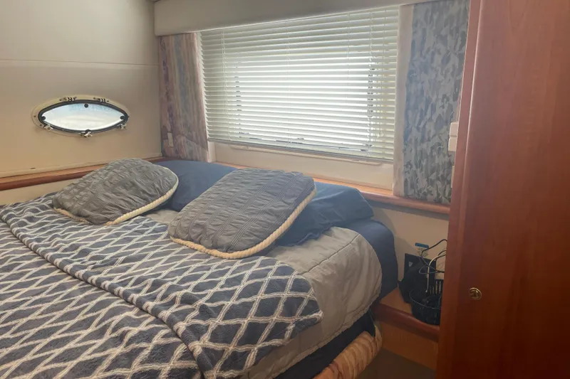 Slide: The Image of Cozy bedroom interior of 1999 Silverton 322 Motor Yacht with bed and window blinds. - 14