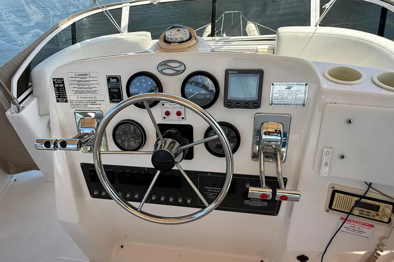 Slide: The Image of 1999 Silverton 322 Motor Yacht helm with steering wheel, gauges, and controls. - 17