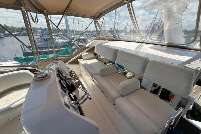 Slide: The Image of 1999 Silverton 322 Motor Yacht interior with helm and seating, docked at marina. - 18