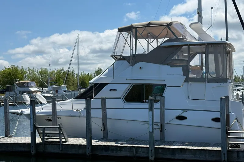 Slide: The Image of 1999 Silverton 322 Motor Yacht docked at marina under blue sky. - 2