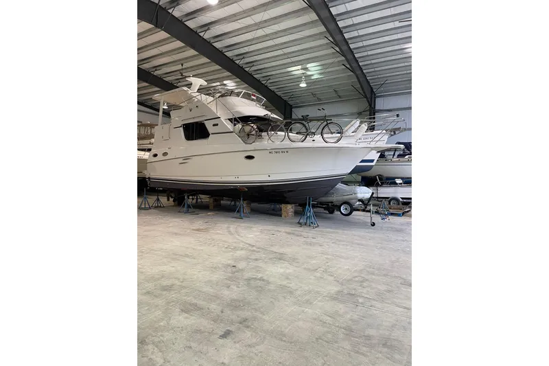Slide: The Image of 1999 Silverton 322 Motor Yacht in storage, elevated on stands, with bicycles on deck. - 28