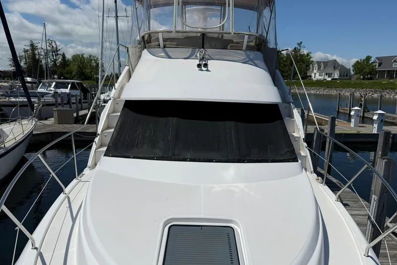 Slide: The Image of 1999 Silverton 322 Motor Yacht docked at a marina under a clear blue sky. - 3