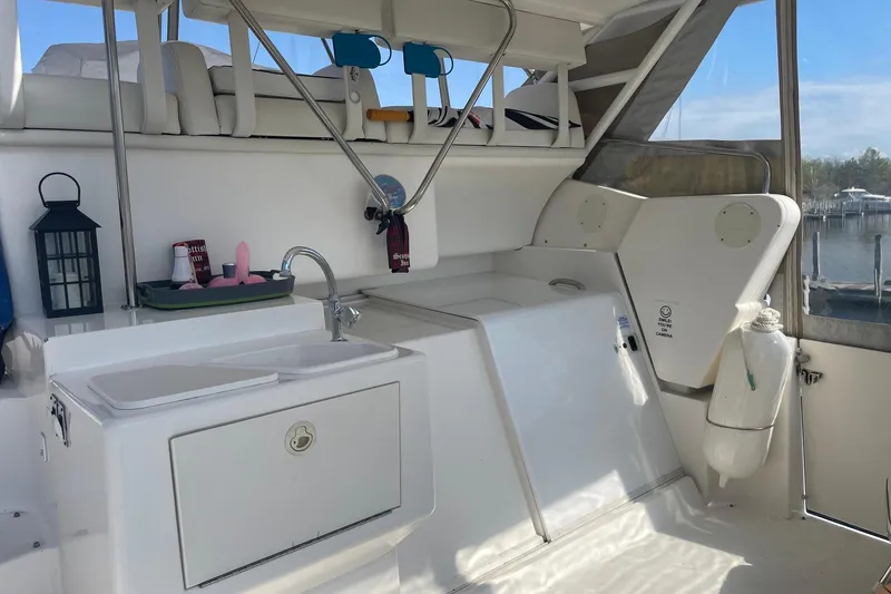 Slide: The Image of 1999 Silverton 322 Motor Yacht interior with sink, seating, and marina view. - 6