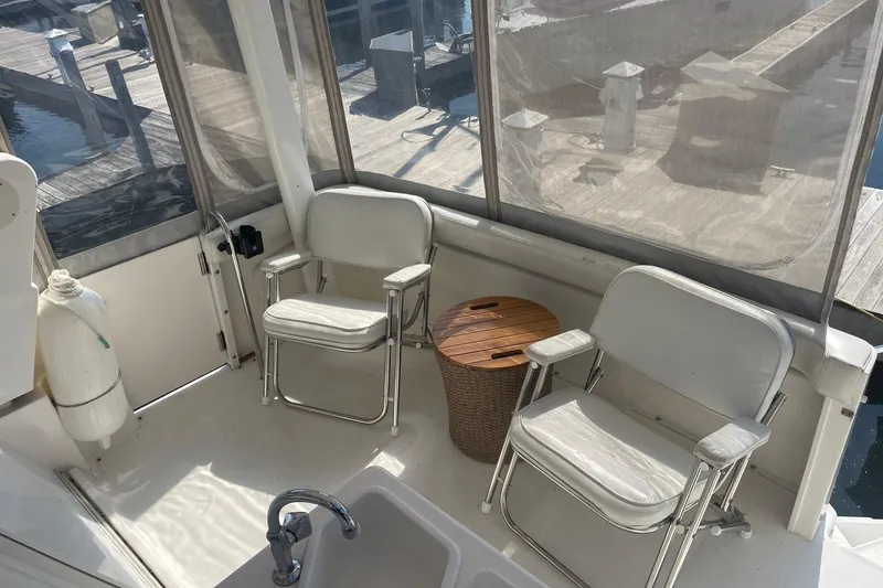 Slide: The Image of 1999 Silverton 322 Motor Yacht interior with chairs and table on deck. - 7