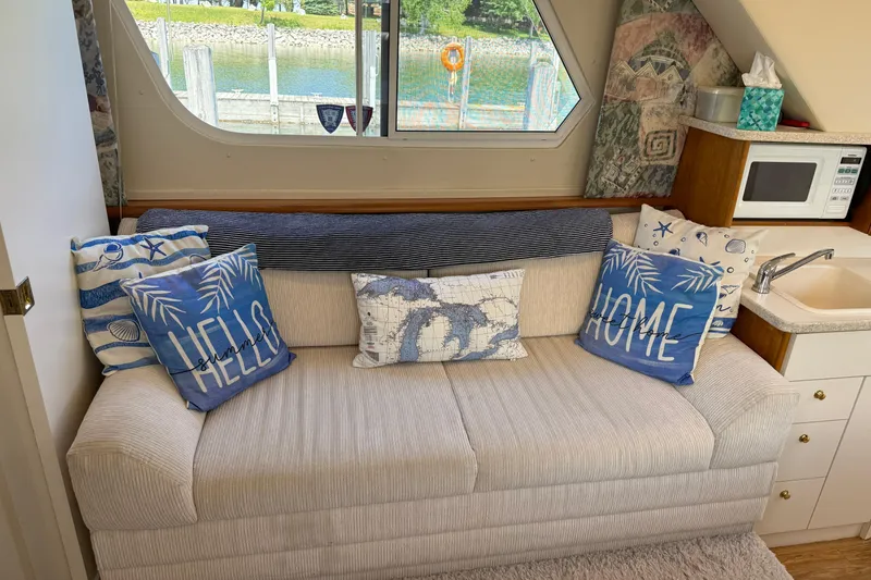 Slide: The Image of Cozy interior of 1999 Silverton 322 Motor Yacht with nautical-themed pillows and kitchenette. - 8