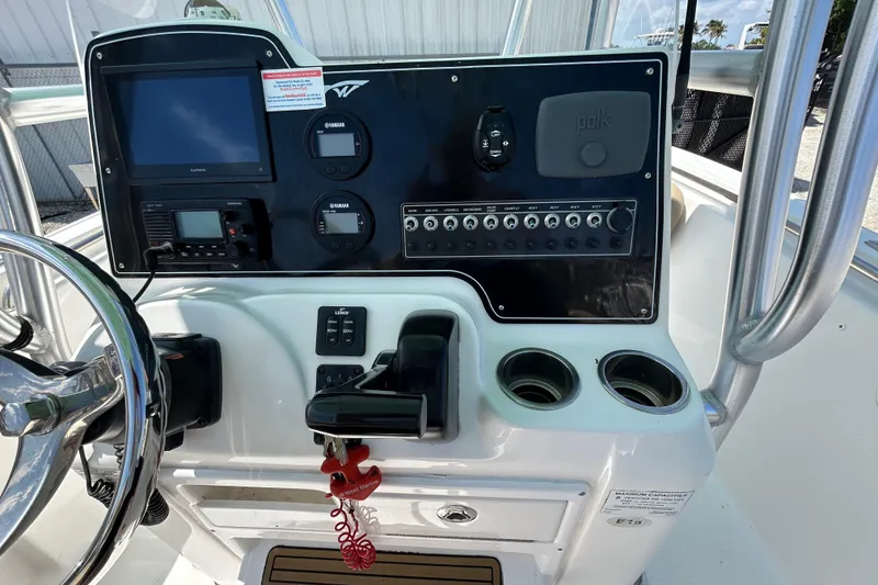 Slide: The Image of 2016 Tidewater 210 LXF boat dashboard with navigation controls and cup holders. - 20