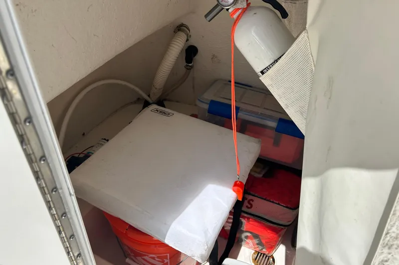 Slide: The Image of Storage compartment of a 2016 Tidewater 210 LXF boat with safety equipment and supplies. - 26