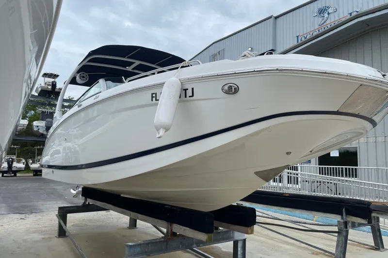 Slide: The Image of 2022 Four Winns HD8 OB boat on display at a marina, showcasing sleek design. - 12