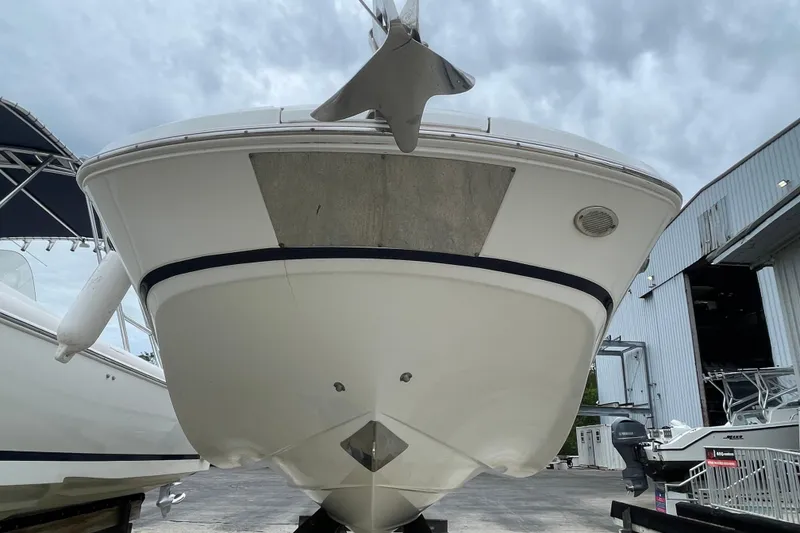 Slide: The Image of 2022 Four Winns HD8 OB boat, front view, docked at a marina under cloudy skies. - 13