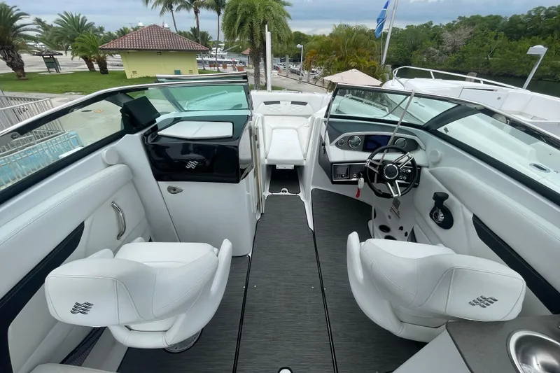 Slide: The Image of 2022 Four Winns HD8 OB boat interior with white seating and modern dashboard. - 15