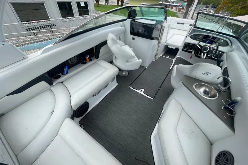 Slide: The Image of 2022 Four Winns HD8 OB boat interior with white seating, steering wheel, and sink. - 17