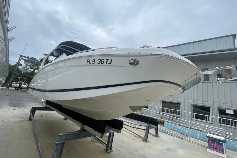 Slide: The Image of 2022 Four Winns HD8 OB boat on display, elevated on a stand, with overcast sky. - 18