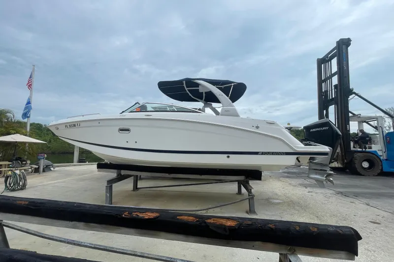 Slide: The Image of 2022 Four Winns HD8 OB boat on a lift, with a cloudy sky backdrop. - 19
