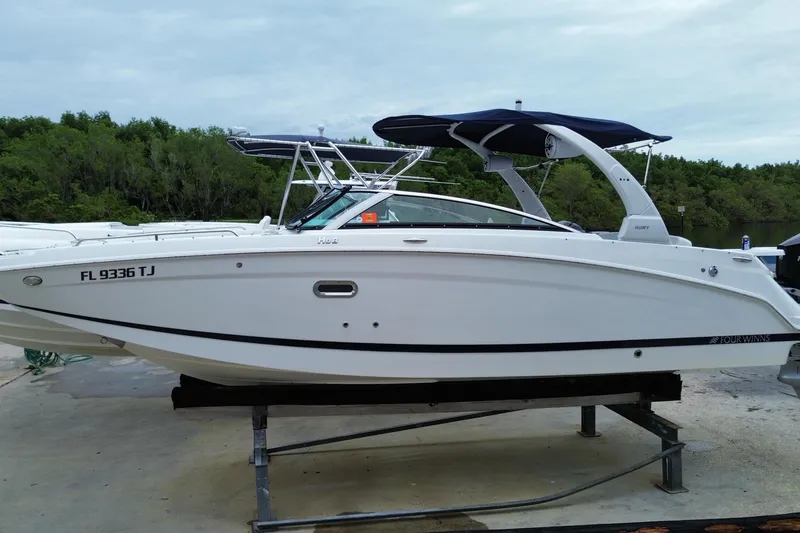Slide: The Image of 2022 Four Winns HD8 OB boat on a stand, featuring sleek design and canopy. - 2