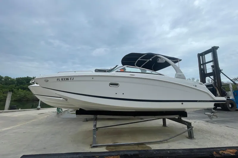 Slide: The Image of 2022 Four Winns HD8 OB boat on a lift, featuring sleek white design and canopy. - 20