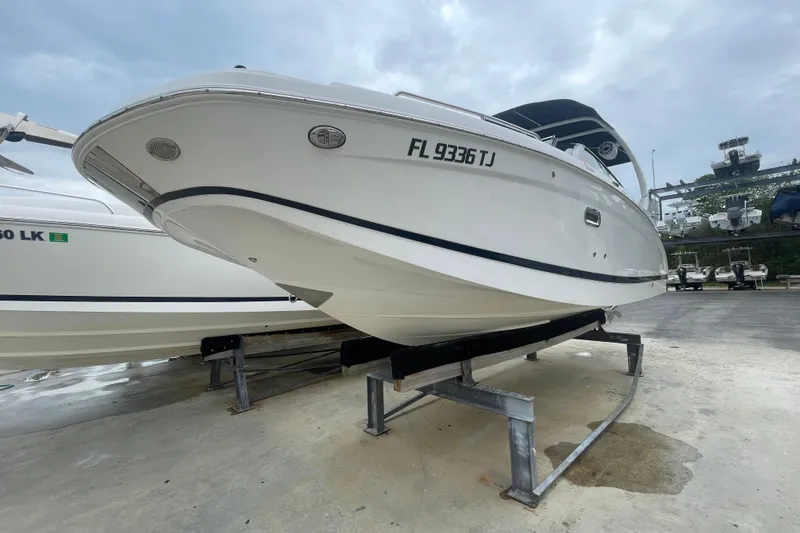 Slide: The Image of 2022 Four Winns HD8 OB boat on display, elevated on a stand, with overcast sky. - 22