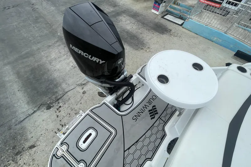 Slide: The Image of 2022 Four Winns HD8 OB boat with Mercury outboard motor and deck table. - 31