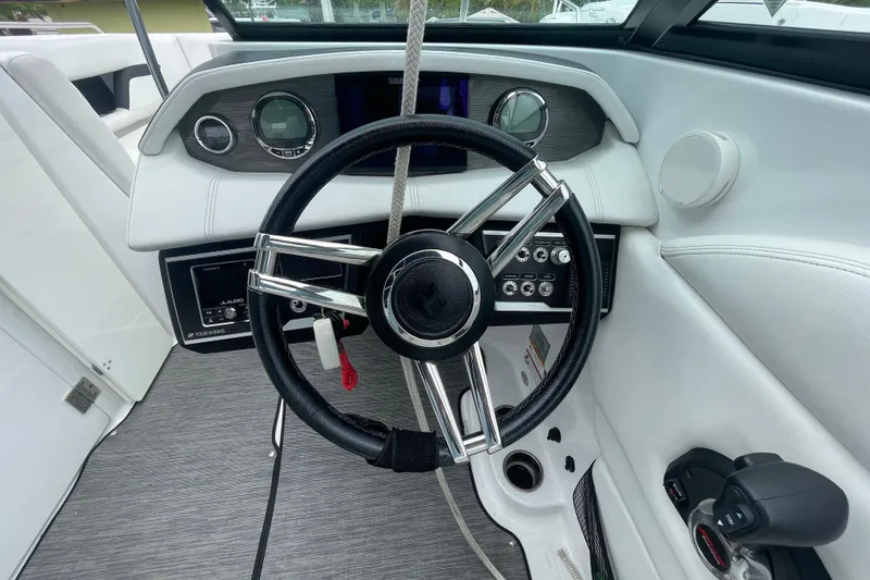 Slide: The Image of 2022 Four Winns HD8 OB boat dashboard with steering wheel and controls. - 36