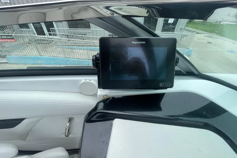Slide: The Image of 2022 Four Winns HD8 OB boat dashboard with Raymarine display and white seating. - 37