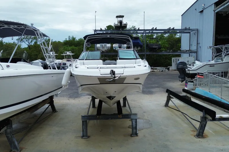 Slide: The Image of 2022 Four Winns HD8 OB boat on display at a marina, surrounded by other vessels. - 4