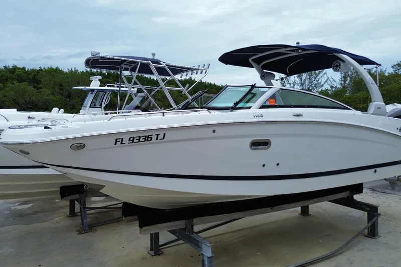 Slide: The Image of 2022 Four Winns HD8 OB boat with sleek design, docked on a platform. - 6