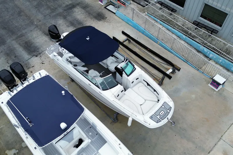 Slide: The Image of 2022 Four Winns HD8 OB boat with navy canopy, docked beside another vessel. - 8