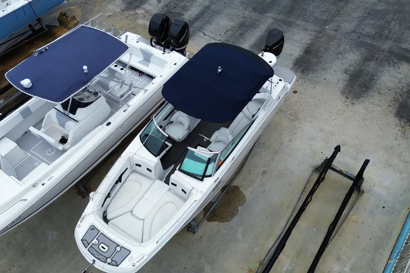 Slide: The Image of 2022 Four Winns HD8 OB boat with blue canopy, docked alongside another vessel. - 9