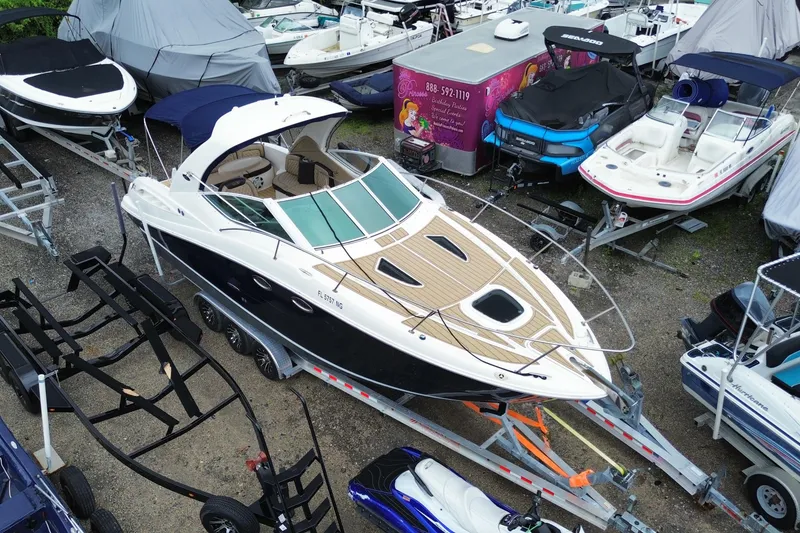 Slide: The Image of 2006 Sea Ray 290 Sundancer boat on trailer, surrounded by other boats in storage. - 11