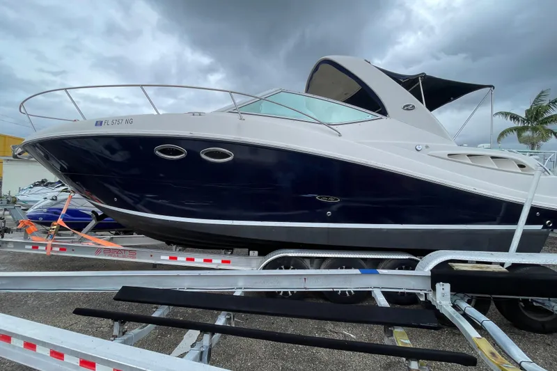 Slide: The Image of 2006 Sea Ray 290 Sundancer boat on trailer under cloudy sky. - 16