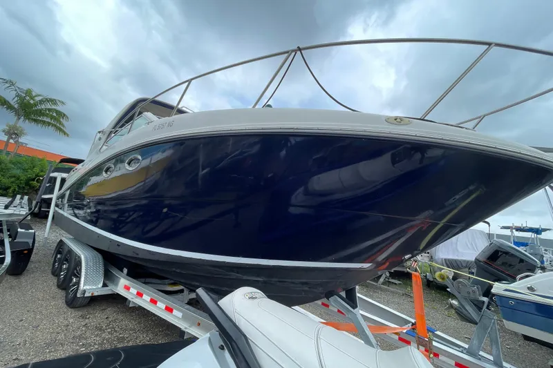 Slide: The Image of 2006 Sea Ray 290 Sundancer boat on trailer, under cloudy sky. - 17