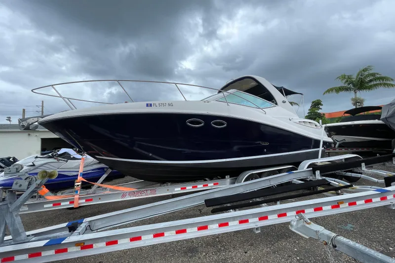Slide: The Image of 2006 Sea Ray 290 Sundancer boat on trailer under cloudy sky. - 18