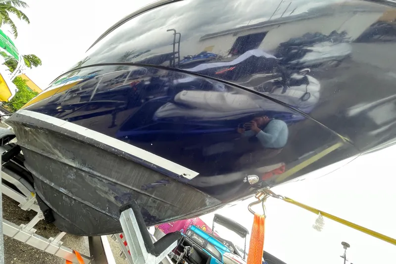 Slide: The Image of 2006 Sea Ray 290 Sundancer boat on trailer, secured with straps, reflecting surroundings. - 21