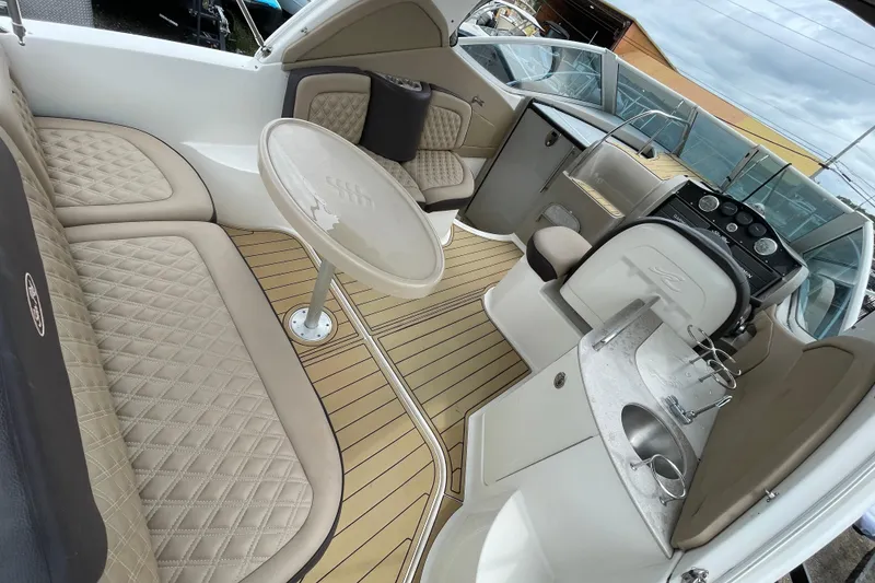 Slide: The Image of 2006 Sea Ray 290 Sundancer interior with beige seating, table, and helm. - 24